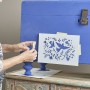 Dekoracje, Nowa metamorfoza mebla od Annie Sloan  - odkryj moc kolorów! - Krok 1:
Nałóż dwie warstwy farby kredowej Chalk Paint w kolorze Napoleonic Blue na całą powierzchnię mebla za pomocą pędzla (pozwól farbie wyschnąć przed nałożeniem drugiej warstwy).