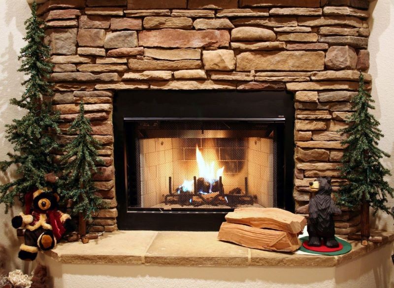 Ścianę nad kominkiem można wyłożyć kamieniem naturalnym.