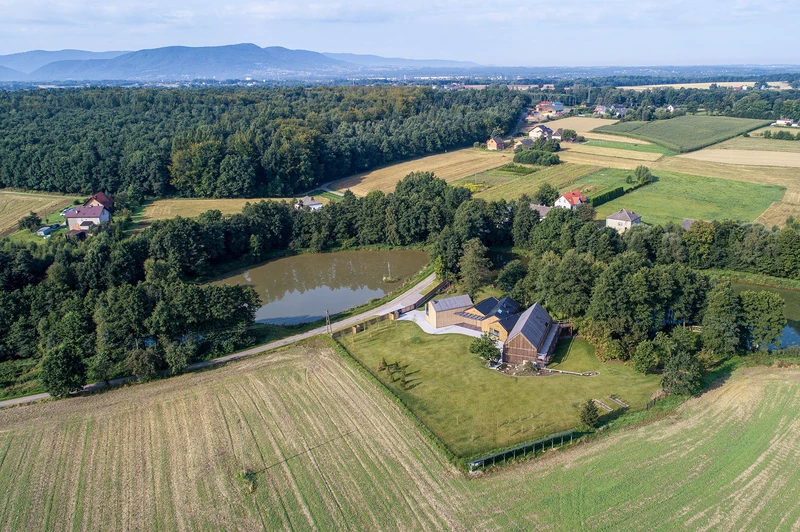 Domy i mieszkania, Polska Zagroda - polski projekt nowoczesnej stodoły - Architekci z BXBstudio dokonali transformacji typowego wiejskiego gospodarstwa w nowoczesną rezydencję. Ich projekt jest innowacyjny i oryginalny, ale nie zapomina o tym, gdzie powstał. Budynki wpasowują się w przestrzeń — zbudowane są z poszanowaniem środowiska naturalnego, a także wykorzystują naturalne światło. Elewacja zbudowana jest z czerwonych cegieł i drewna tak jak stodoły stojące tutaj wcześniej.

Projekt: BXB studio.
Fot. Piotr Krajewski