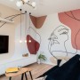 Domy i mieszkania, TWARZOWY KORAL - Rozrzucono go w przemyślany sposób na różne elementy – ścianę i płytki w kuchni, ściany korytarza, zabudowę meblową w łazience, a przede wszystkim – wielkopowierzchniową nowoczesną grafikę z linearnym portretem, zdobiącą boczną ścianę salonu. 
fot. KODO