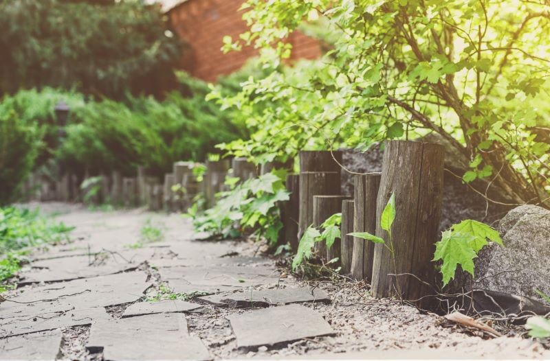 Ścieżkę w rustykalnym ogrodzie mogą otaczać pnie lub konary.