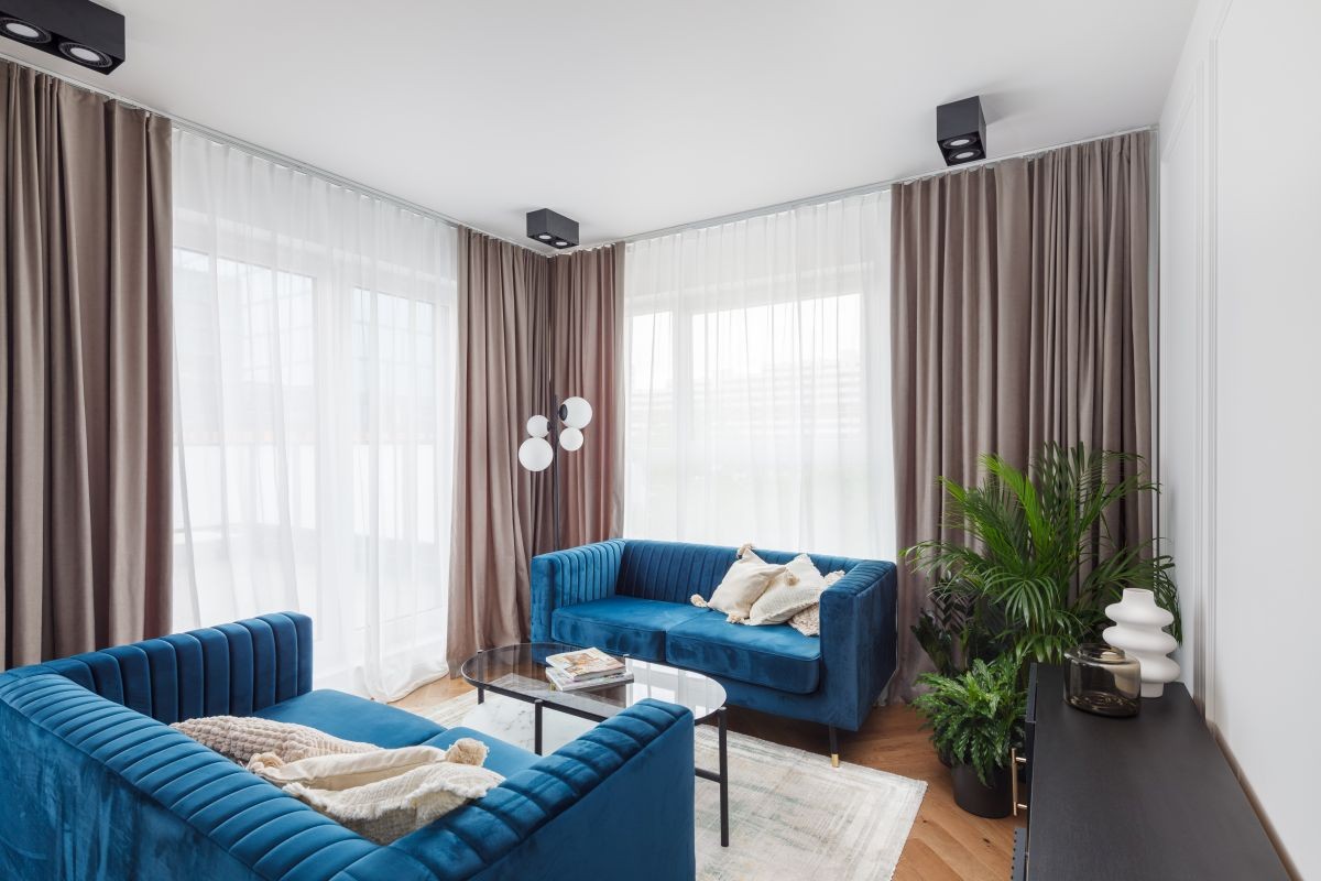 Domy i mieszkania, Apartament dla rodziny w sercu Wrocławia - Ściany w salonie są białe, co w połączeniu z eleganckimi sztukateriami nadaje wnętrzu niezwykle szykownego charakteru. Mocnymi elementami salonu, które natychmiast przyciągają wzrok, są dwie welurowe kanapy w kolorze głębokiego błękitu. Z kolei minimalistyczne czarne meble wprowadzają do wnętrza klimat rodem z epoki art déco.
Klienci doceniają realizowany przez Grupę Rosmarino projekt Nowe Centrum Południowe, co najlepiej obrazuje bardzo dobra sprzedaż mieszkań w ramach tej inwestycji.  W zrealizowanych dotychczas trzech etapach Nowego Centrum Południowego powstało łącznie 751 mieszkań, z których 744 znalazły już swoich właścicieli. W przygotowaniu jest kolejny – czwarty etap inwestycji, który już w tej chwili budzi duże zainteresowanie naszych klientów.